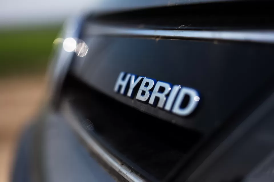 Close-up of HYBRID logo on back of black car.